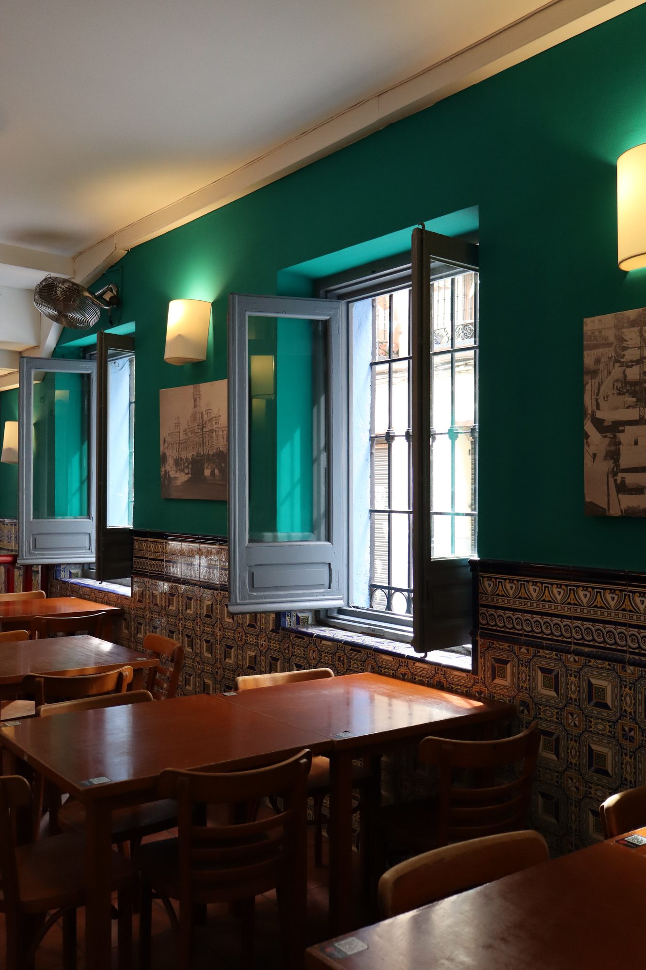 Comedor de El Económico con paredes verdes y zócalo de azulejos