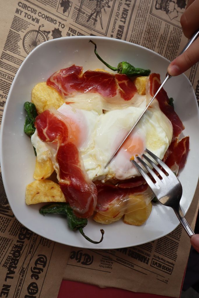 Huevos rotos con jamón, patatas y pimientos